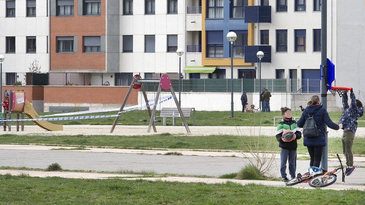 Niños jugando junto a un parque infantil clausurado. ISRAEL L. MURILLO
