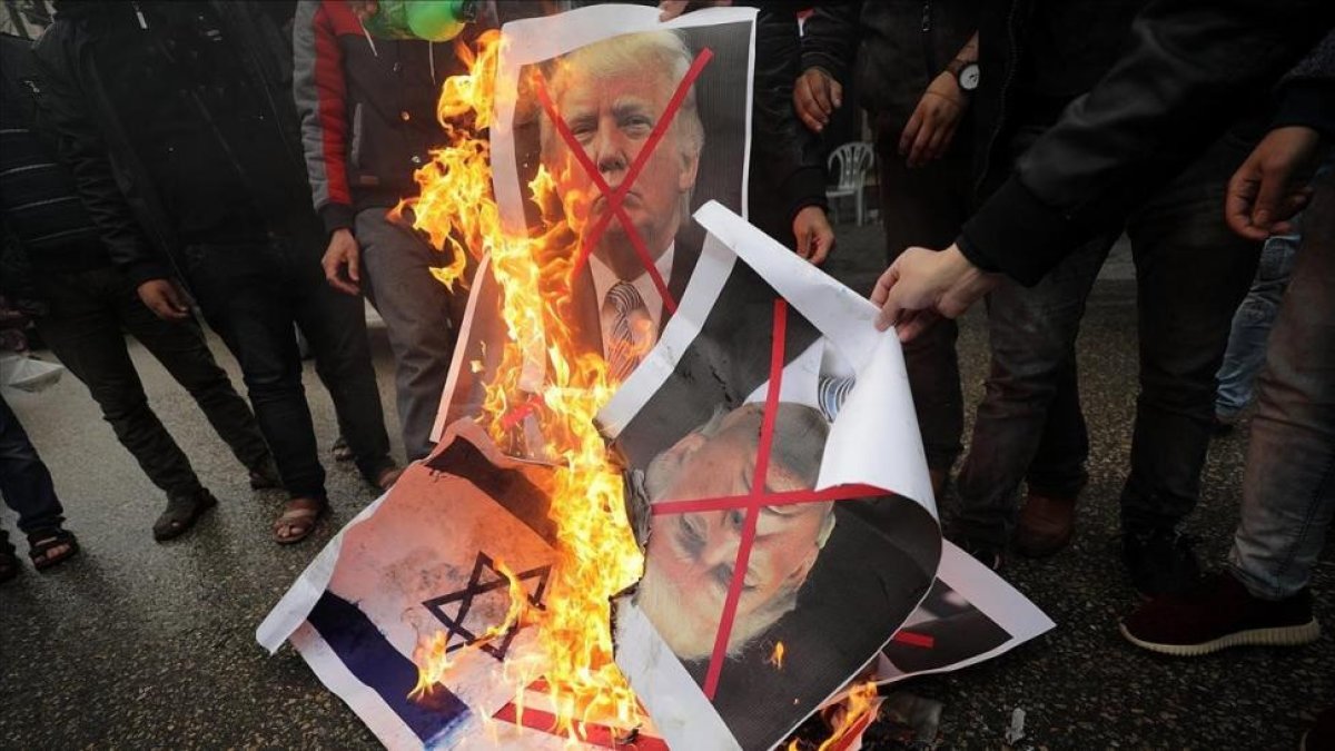Varios palestinos, contrarios a la decisión de presidente Trump, queman su fotografía y banderas estadounidenses.-MOHAMMED SABER (EFE)