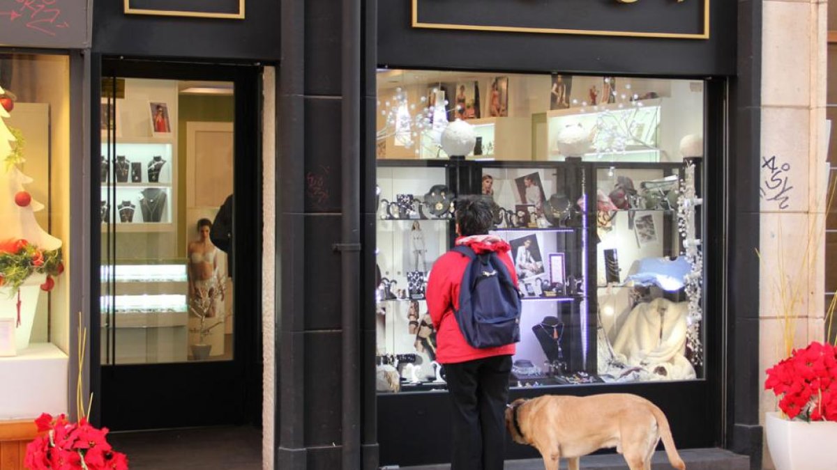 Una persona observa un escaparate de una tienda.-ISRAEL L. MURILLO