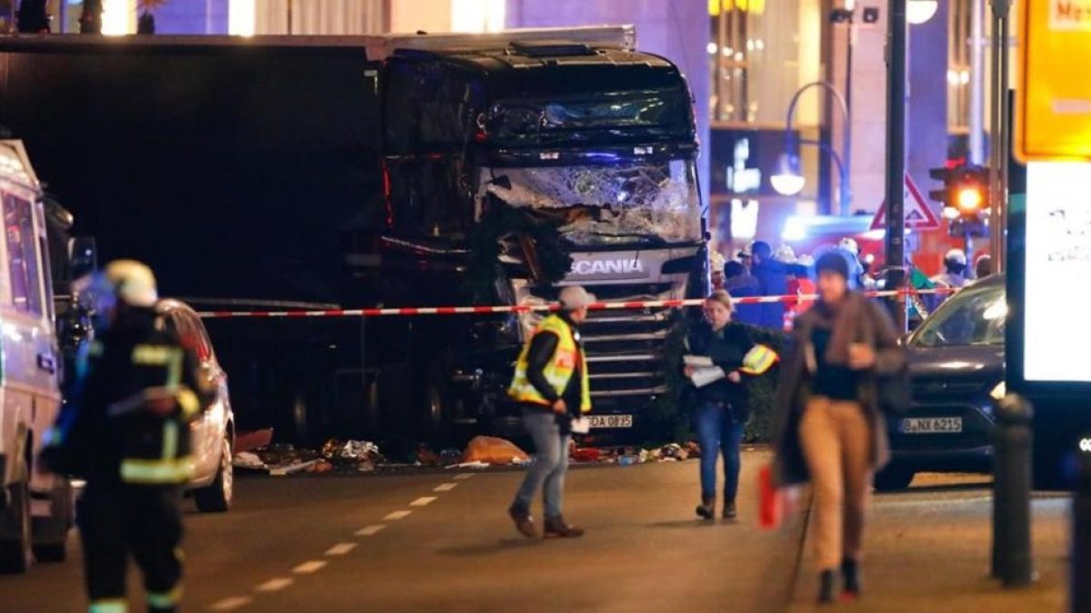 Los servicios de emergencia, junto al camión que causó la tragedia en el mercado navideño de Berlín.-REUTERS / FABRIZIO BENSCH