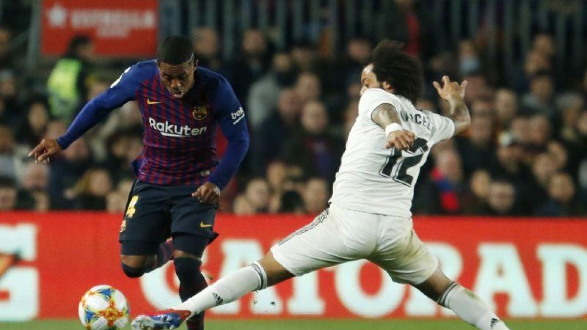 El madridista Marcelo (d) superado por Malcom en un momento del partido ante el Barça.-AFP