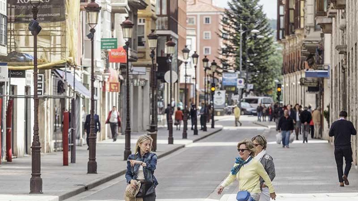 Unas mujeres cruzan la calle Santander en un día festivo.