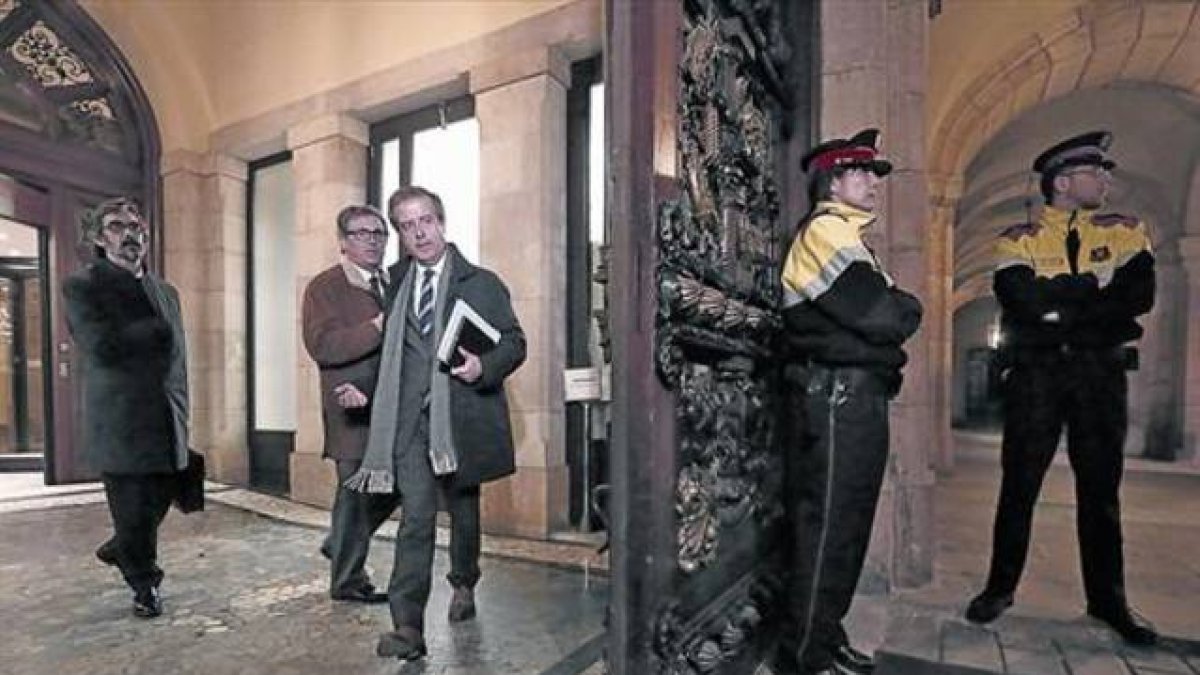 Jordi Pujol Ferrusola (con abrigo marrón) y sus abogados Cristóbal Martell y Albert Carrillo (con corbata de rayas), el 23 de febrero en el Parlament.-Foto: JULIO CARBÓ
