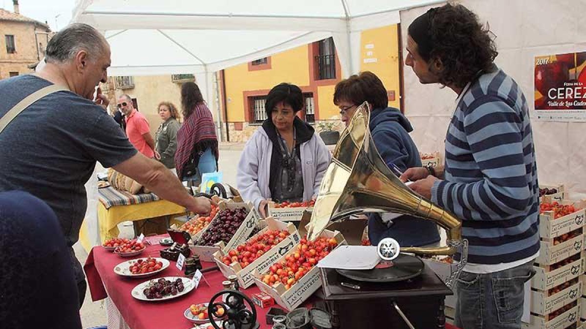 Varias personas rodean un bien decorado puesto de cerezas, ayer en Salas.-G. G.