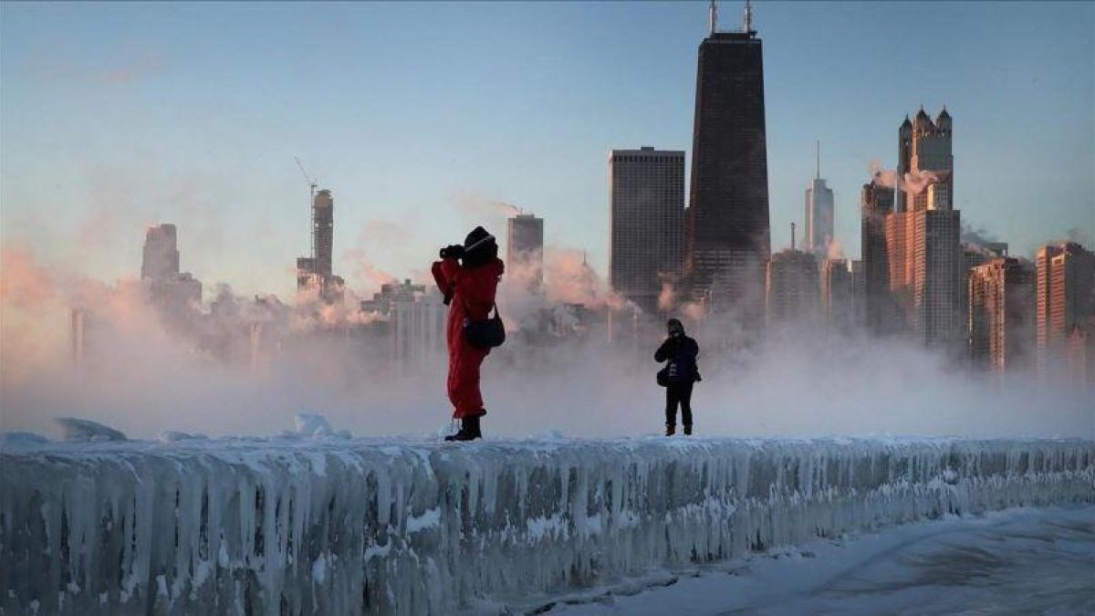 Dos fotógrafos toman imágenes de la tormenta sobre la ciudad de Chicago.-AFP / SCOTT OLSON