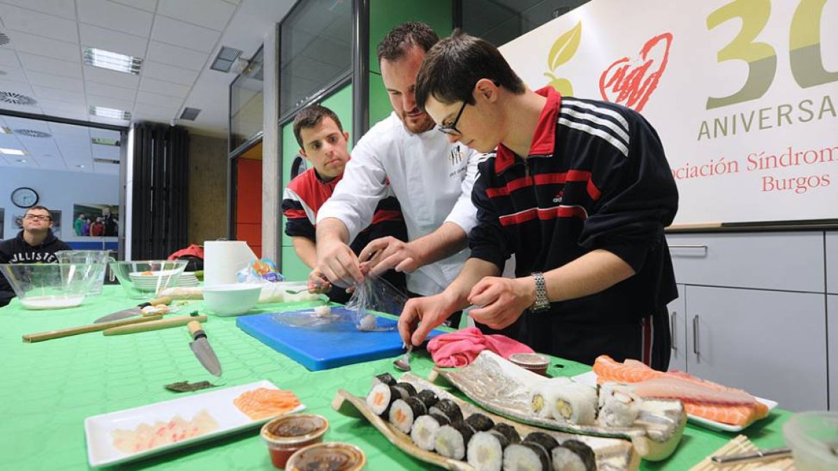 Saúl Gómez enseña a dos de los jóvenes que acudieron a la demostración a elaborar uno de los platos más típicos de la cocina japonesa, el sushi.-ISRAEL L. MURILLO