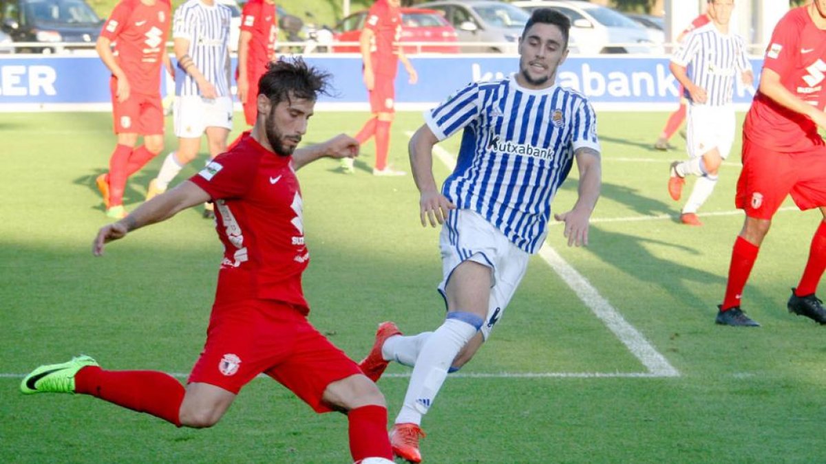 Andrés golpea un esférico ante la presión de un delantero de la Real Sociedad B en el choque de ayer en Zubieta-LUIS M. UNCITI