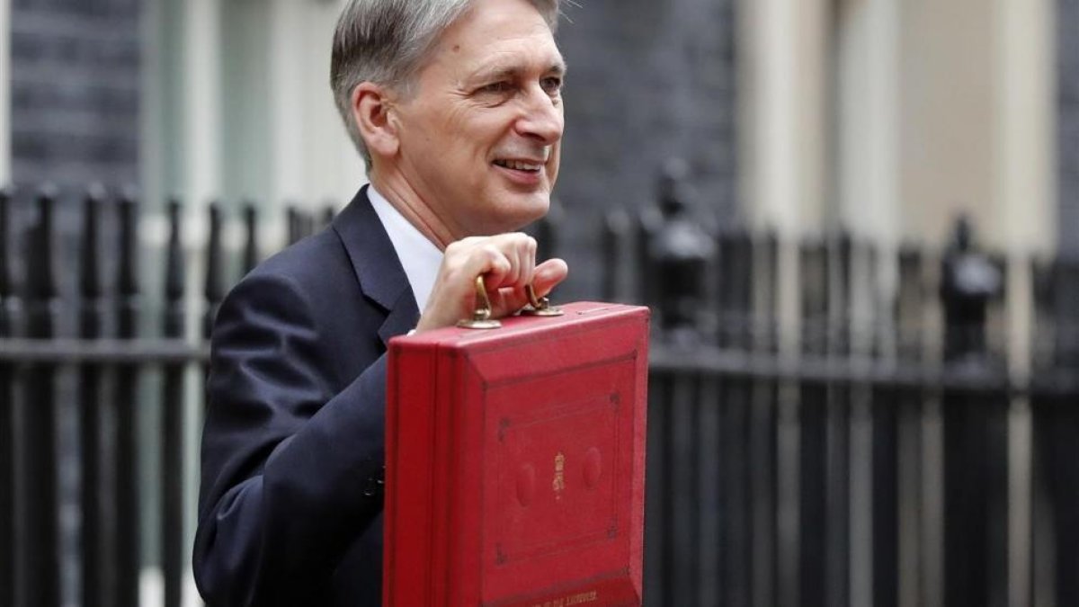 El ministro de Finanzas británico, Philip Hammond, posa con el tradicional maletín rojo del presupuesto.-/ AP / FRANK AUGSTEIN