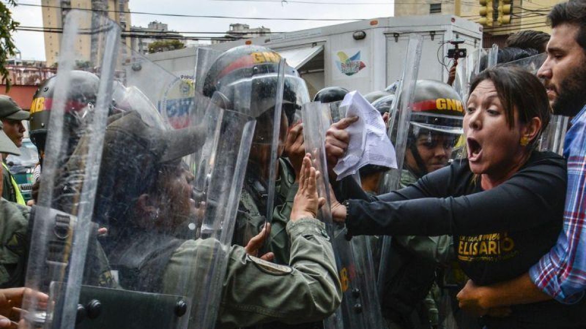 La diputada opositora Amelia Belisario se encara con la policía, en una protesta ante el Supremo, el jueves en Caracas.-AFP / JUAN BARRETO