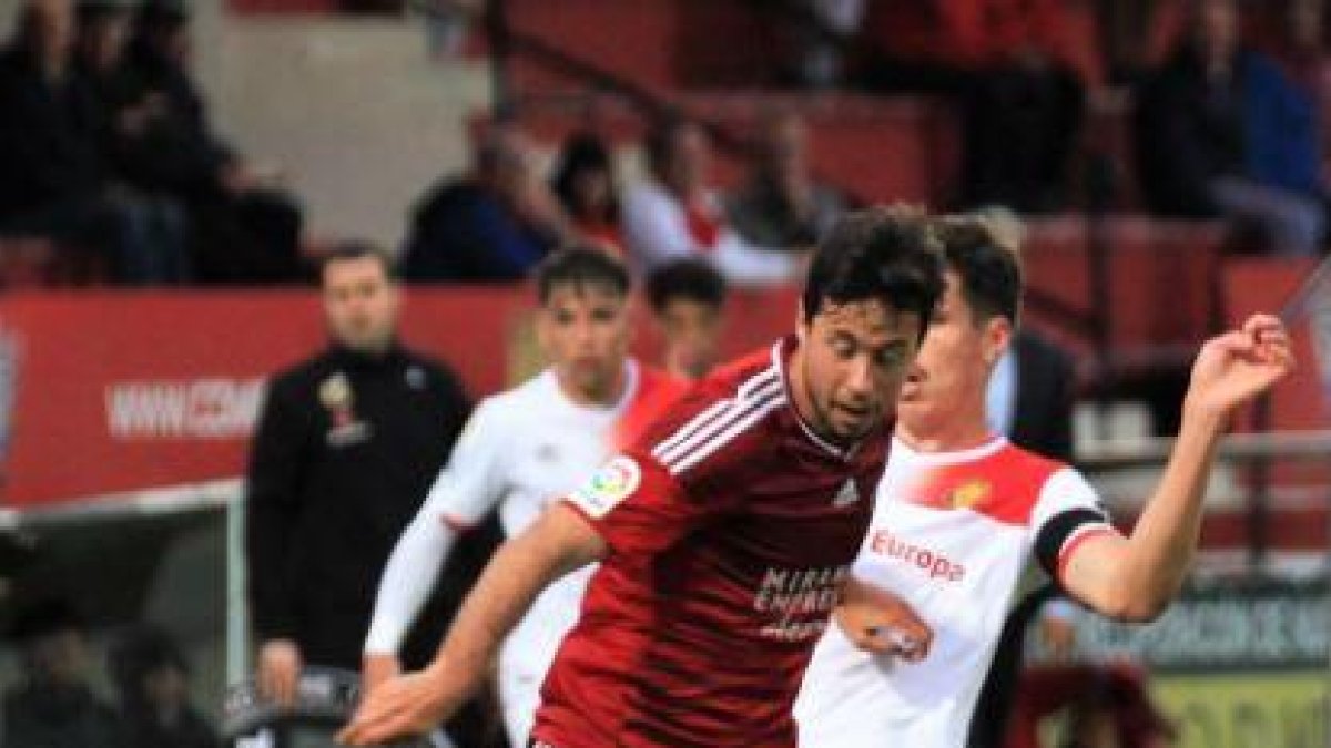 Pedro Martín trata de deshacerse de un jugador del Real Mallorca ayer en el choque disputado en Anduva.-ALFONSO G. MARDONES