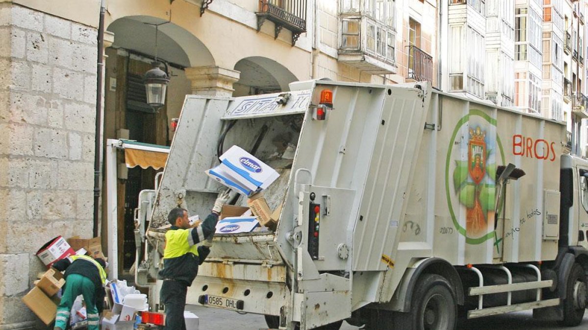 Dos operarios recogen cartón en el centro de la ciudad.-RAÚL G. OCHOA