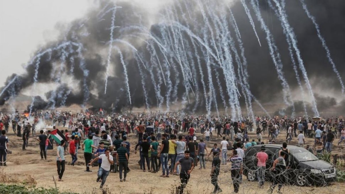 Manifestantes palestinos huyen de los gases lacrimógenos lanzados por los soldados israelís.-/ AFP / MAHMUD HAMS