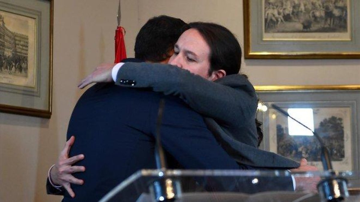 Abrazo entre Pedro Sánchez y Pablo Iglesias tras la firma del Gobierno de coalición.-AFP / GABRIEL BOUYS