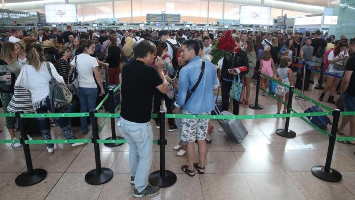 Colas en los controles de seguridad de El Prat este jueves.-ELISENDA PONS