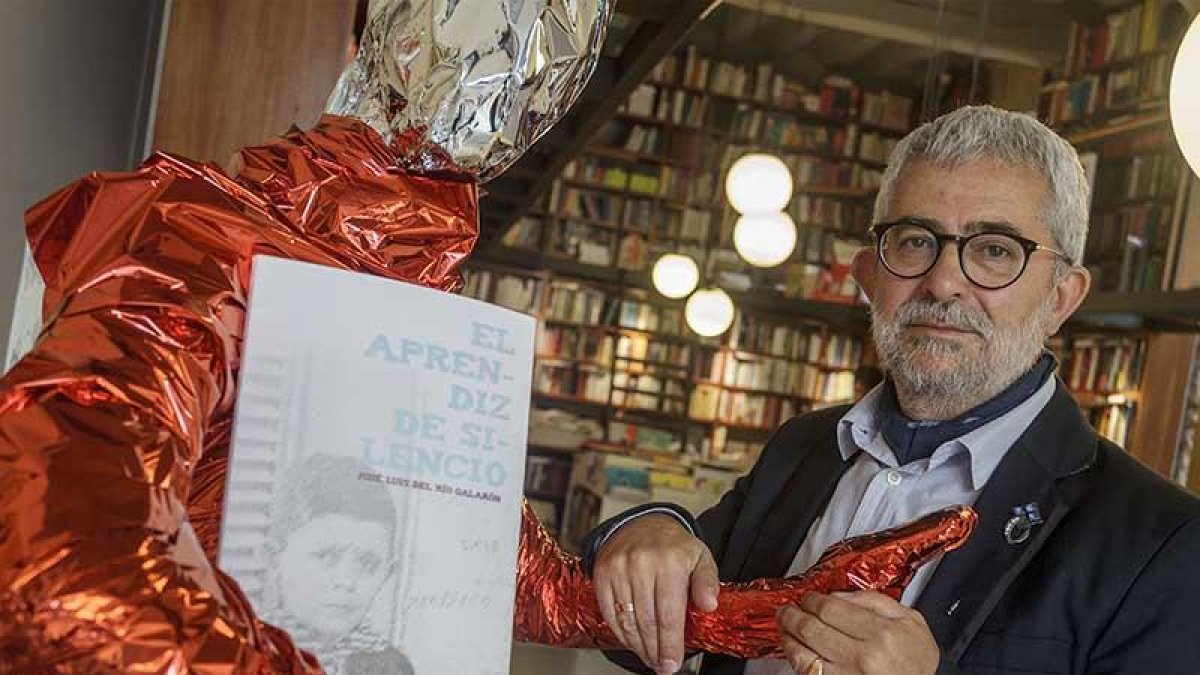 José Luis del Río coge la mano del maniquí que sujeta un ejemplar del libro y que, con distinta vestimenta, ha llamado la atención en Luz y Vida.-Santi Otero