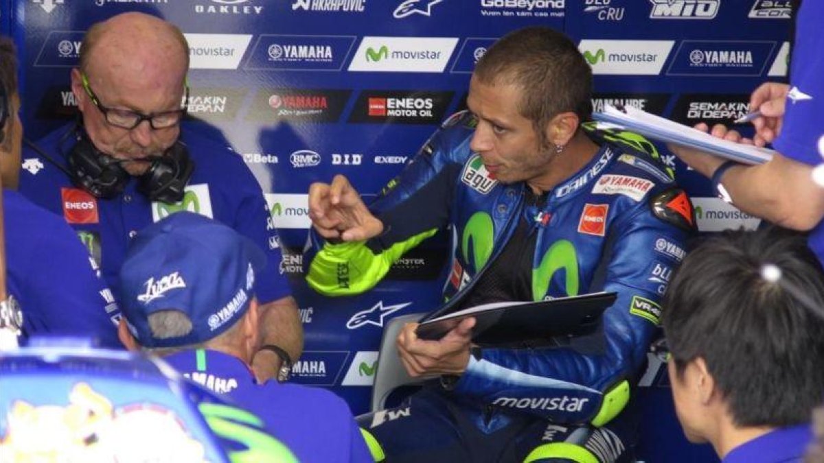 Valentino Rossi expresa las sensaciones de su Yamaha en el test de ayer, en Brno, ante su técnico Silvano Galbusera, a la izquierda.-EMILIO PÉREZ DE ROZAS / ENVIADO ESPECIAL