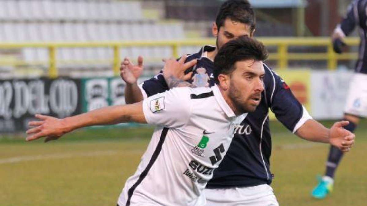 Adrián protege el balón ante la presión de un jugador rival.-SANTI OTERO