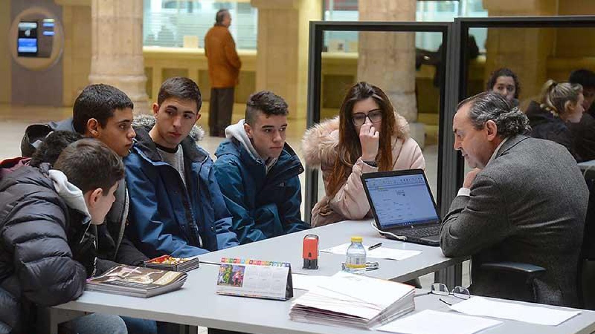 Los escolares representantes de una de las cooperativas atienden a uno de los empleados de la entidad.-R. ORDÓÑEZ