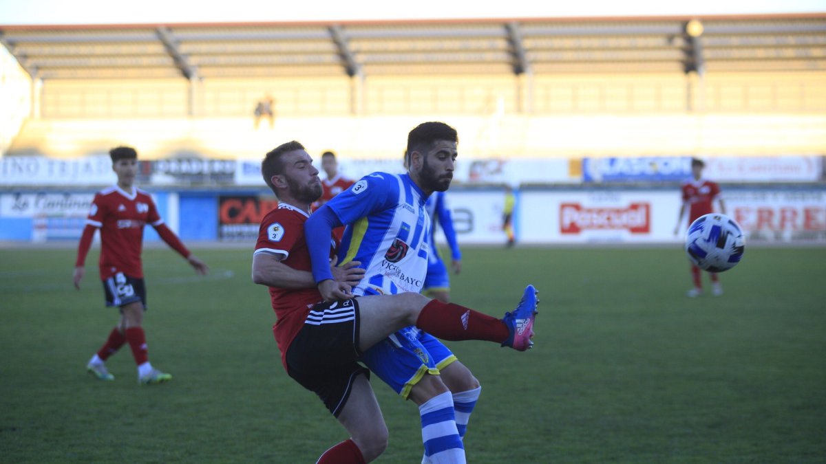 Dani Burgos trata de adelantarse al delantero de la Arandina Édgar Agudo para golpear el balón. ARANDINA CF