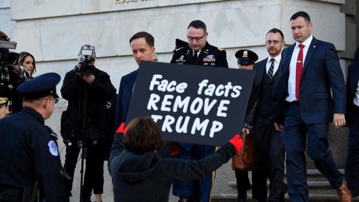 Una mujer protesta contra Trump a las puerta del Congreso a la salida del asesor de seguridad nacional Alexander Vindman, el pasado 19 de noviembre.-AFP