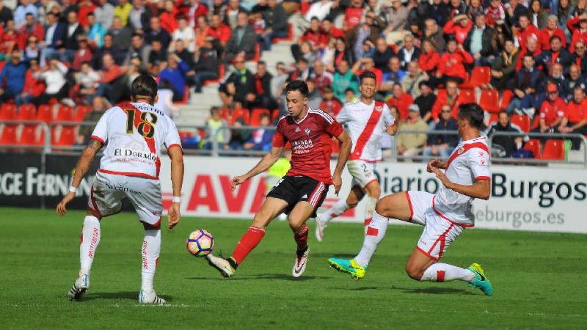 Pedro Martín pasa el balón rodeado de jugadores delRayo en el partido de la primera vuelta disputado en Anduva.-ALFONSO G. MARDONES