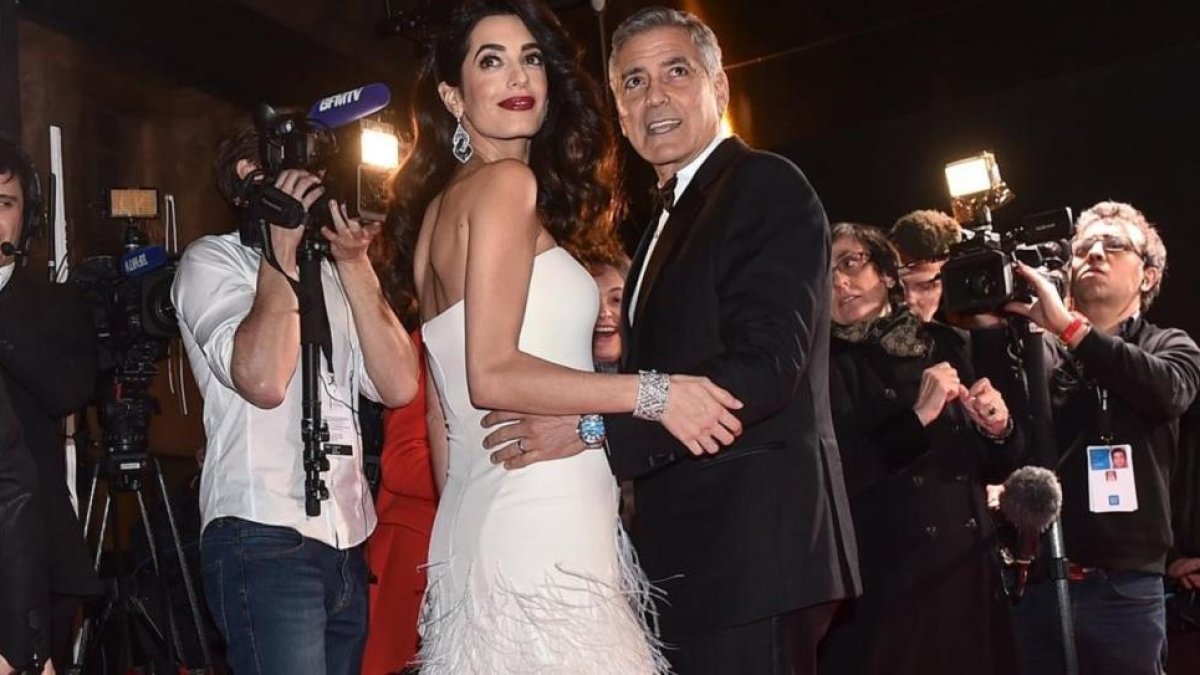 Amal y George Clooney, rodeados de cámaras, el pasado febrero, en la entrega de los Premios César, galardones del cine francés.-EFE
