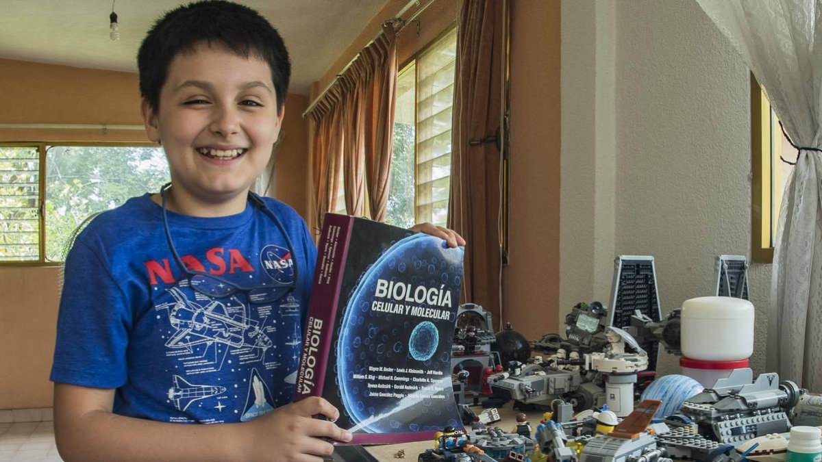 Carlos Antonio, con un libro de biología y sus construcciones de Lego /-UNAM