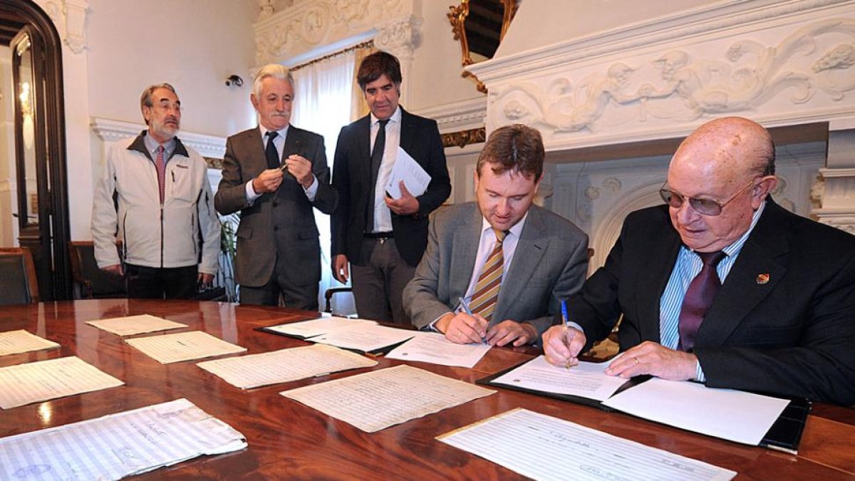 Javier Lacalle y Emilio Miguel Amo (d.) firman el documento de cesión en una solemne estancia del Palacio de Castilfalé.-Israel L. Murillo