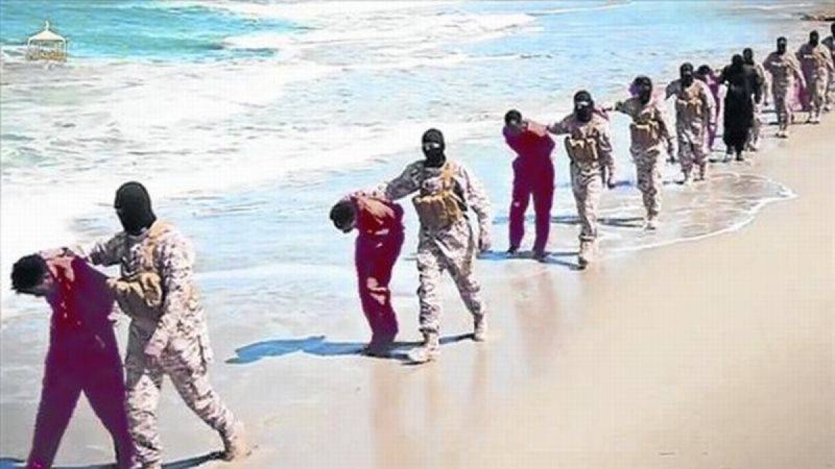 Imagen del vídeo del EI con yihadistas encapuchados conduciendo a sus víctimas por una playa de Libia.-Foto: AP