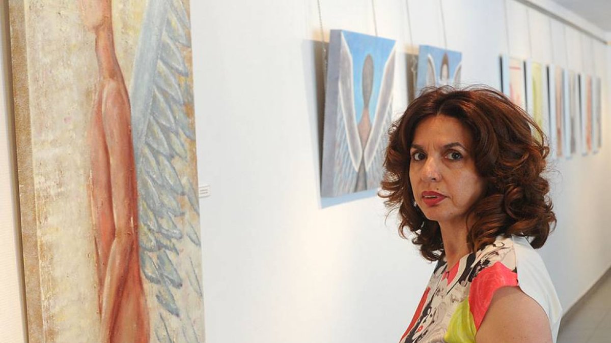Belén de la Parte, junto a algunas de las pinturas realizadas con pigmentos naturales que visten el Espacio de Arte Ural Motor.-Israel L. Murillo