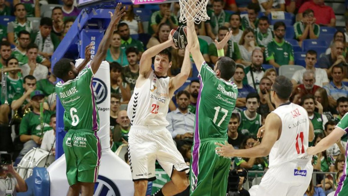 Huskic dobla un balón ante la presión de los jugadores del Unicaja Soluade y Shermadini.-ACB PHOTO / M. POZO