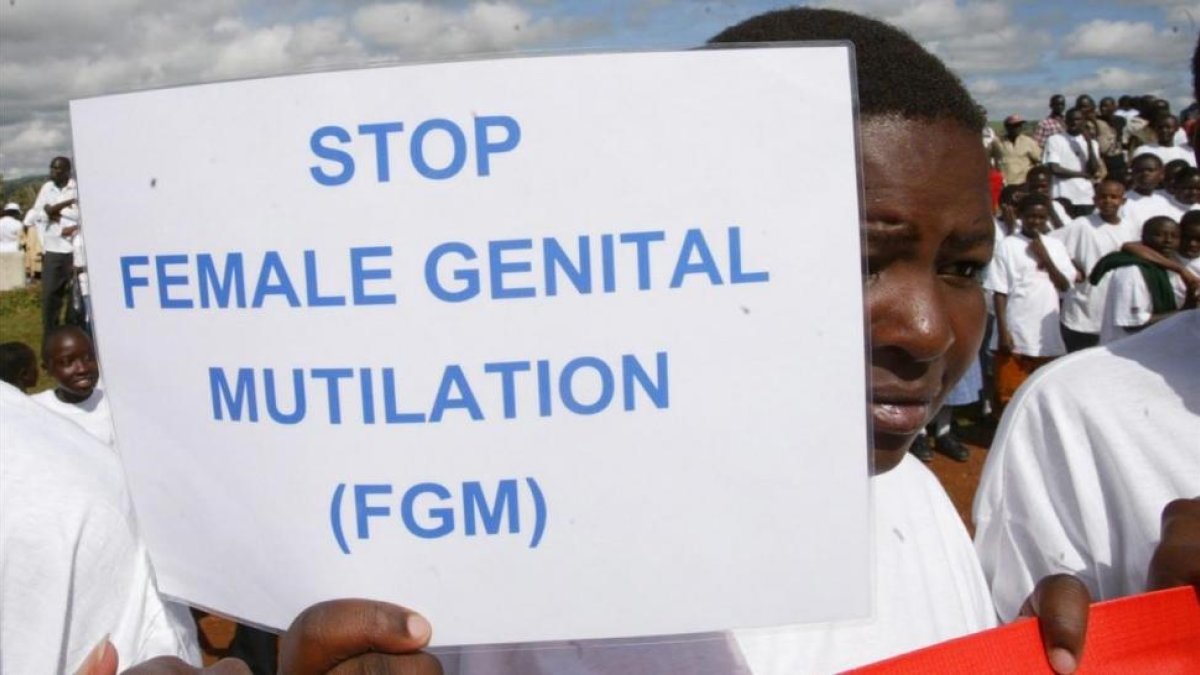 Una mujer sostiene una cartel contra la Mutilación Genital Femenina en una protesta en Kenia.-EL PERIÓDICO