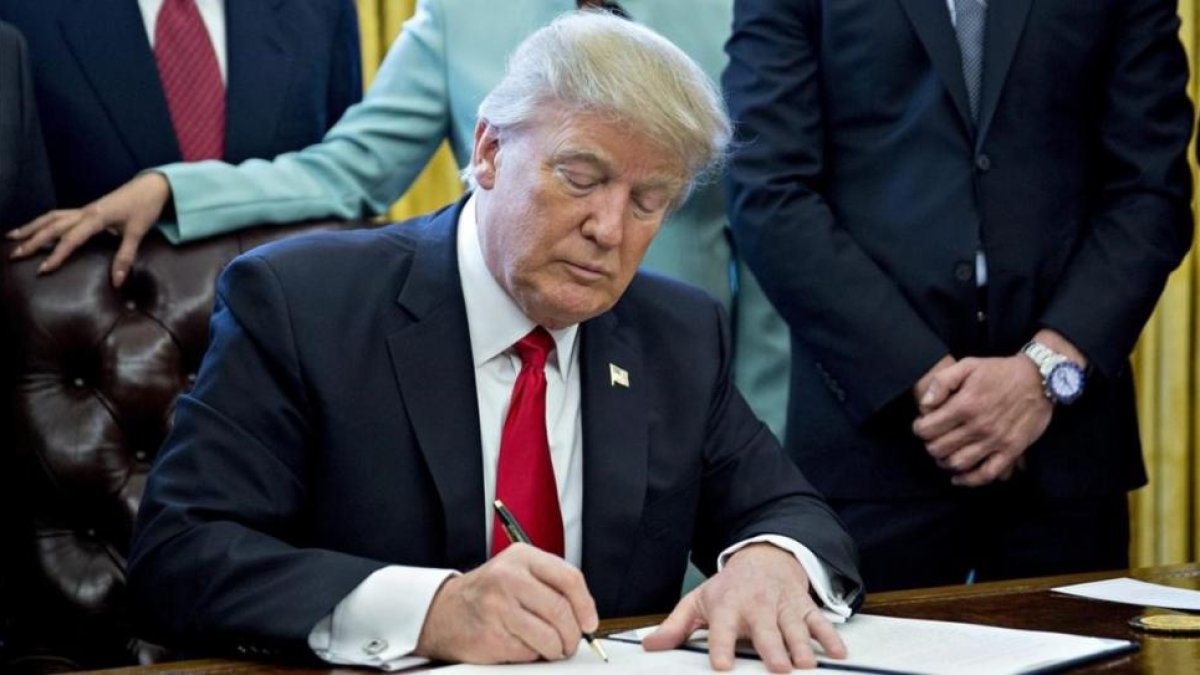 El presidente de Estados Unidos, Donald Trump, firma una orden ejecutiva en el despacho oval.-EFE