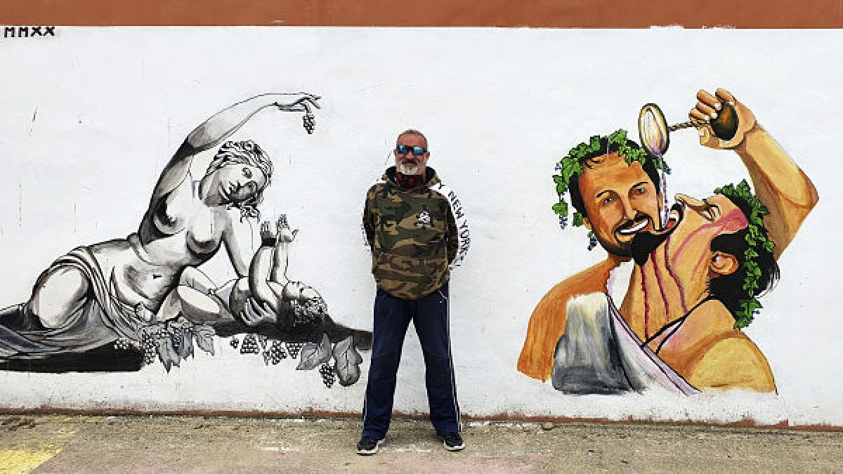 El alcalde de Baños frente a uno de los murales en el pueblo. L. V.