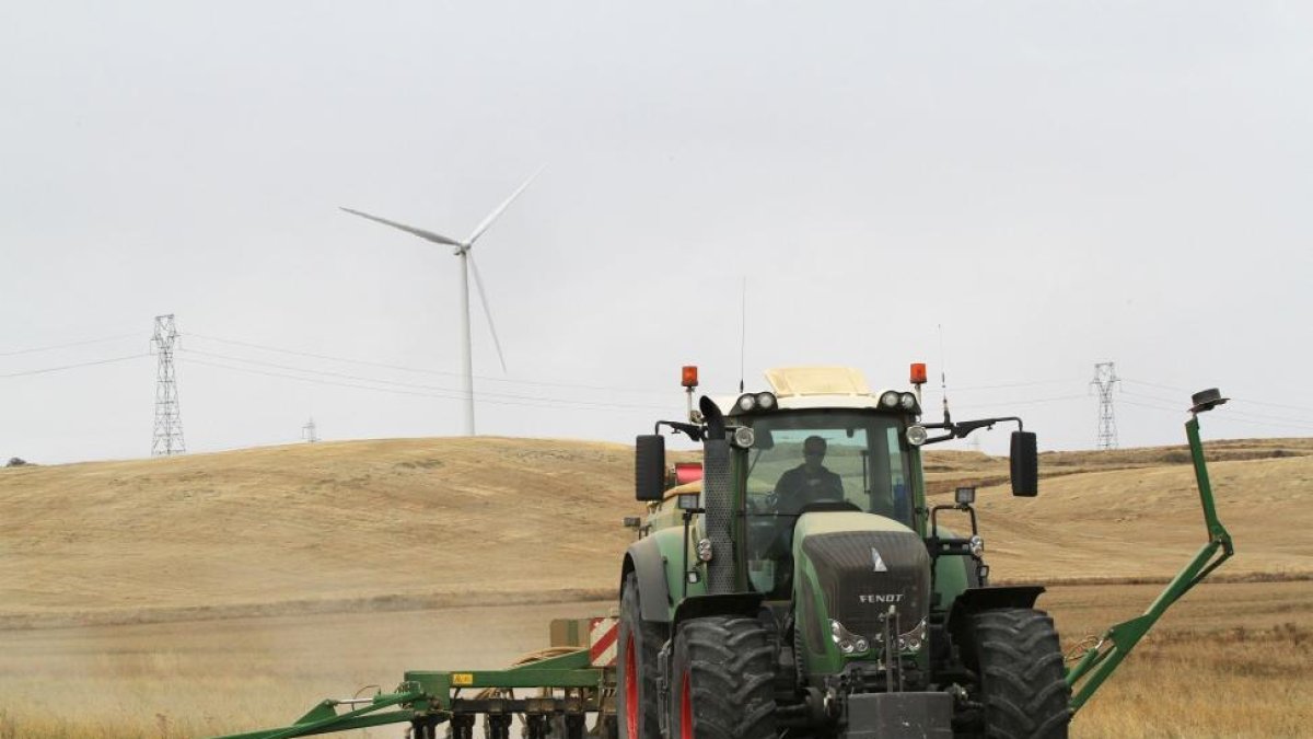 Un agricultor subido al tractor realiza las primeras labores de sementera en la localidad palentina de Fuentes de Valdepero aprovechando las lluvias caídas-BRÁGIMO