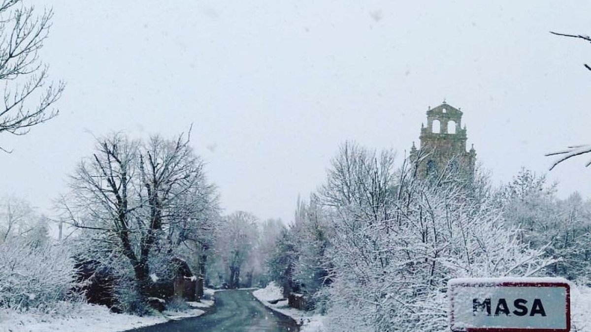La nieve embellece más si cabe el acceso al pueblo.-KIKE DE MIGUEL