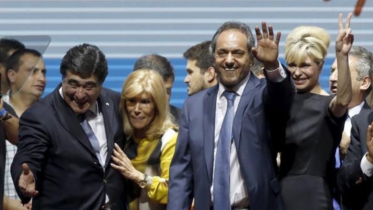Daniel Scioli, segundo por la derecha, saluda junto a su esposa Karina Rabolini y a su candidato a vicepresidente Carlos Zannini en el acto de cierre de campaña en Buenos Aires.-REUTERS / ENRIQUE MARCARIAN