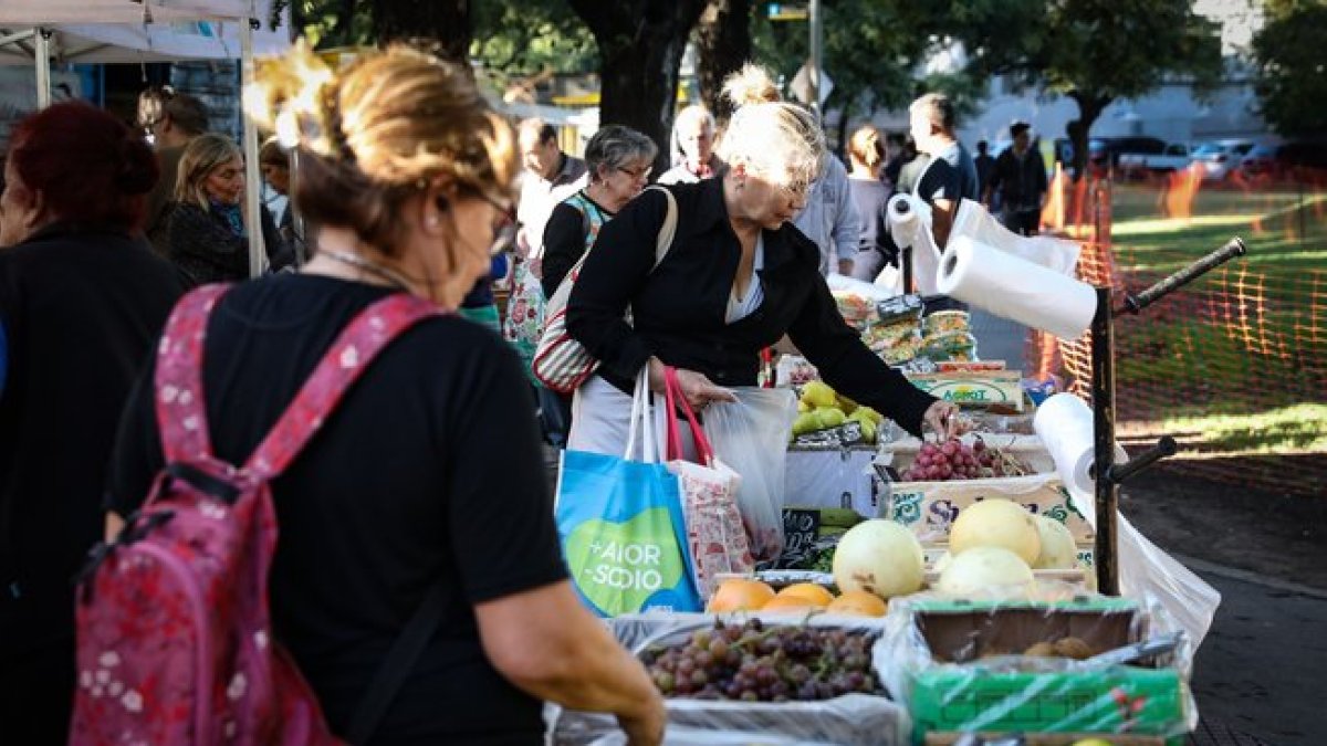 Una mujer compra frutas y verduras en una feria comunitaria para combatir la inflación.-EFE