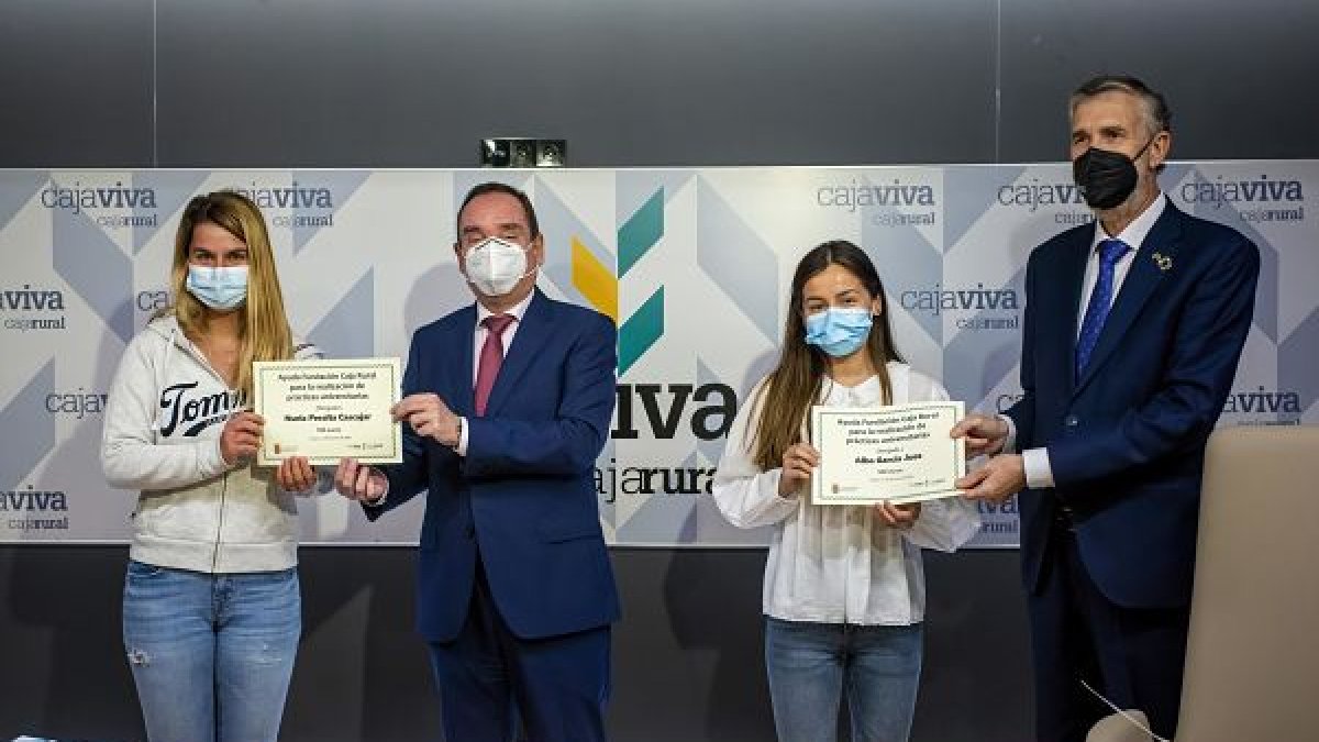 Las alumnas Nuria Peralta y Alba García reciben el diploma que acredita sus prácticas de manos del director general de Cajaviva y del rector de la UBU. SANTI OTERO