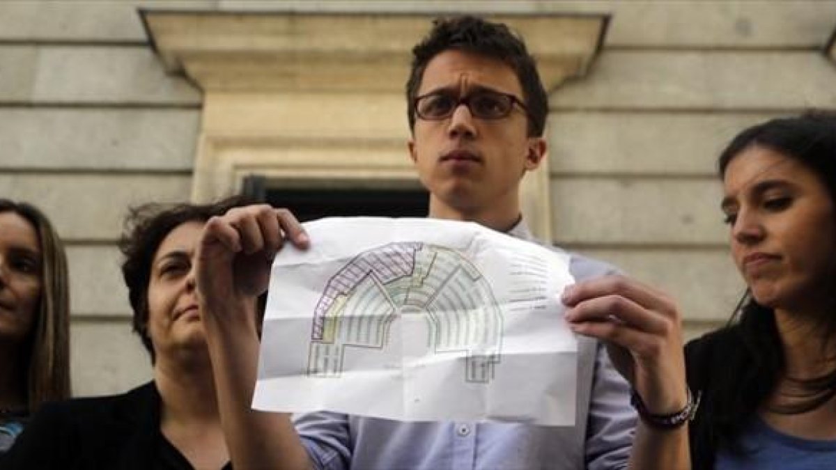 Íñigo Errejón muestra un plano con la distribución de los escaños en el hemiciclo del Congreso, ayer.-AGUSTÍN CATALÁN
