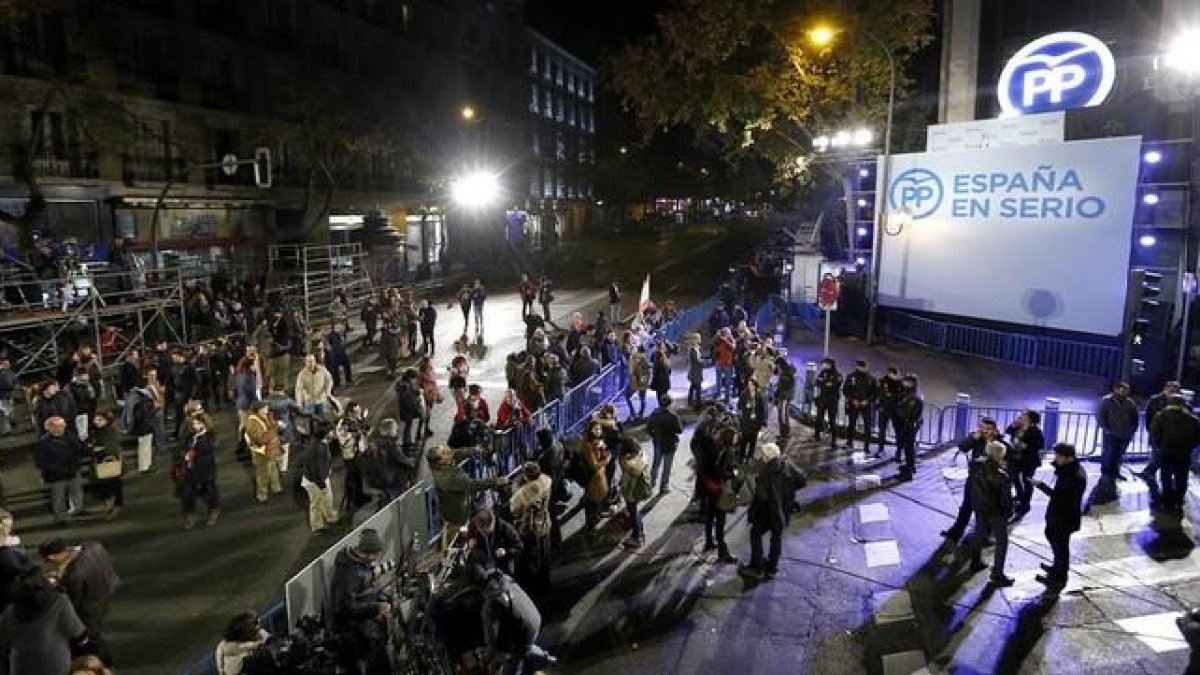 Militantes del PP esperan los resultados electorales en la puerta de la sede de Madrid.-JUAN MANUEL PRATS