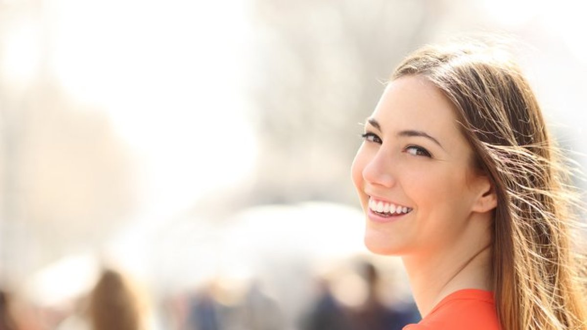 Chica joven sonriendo en la calle.-123RF