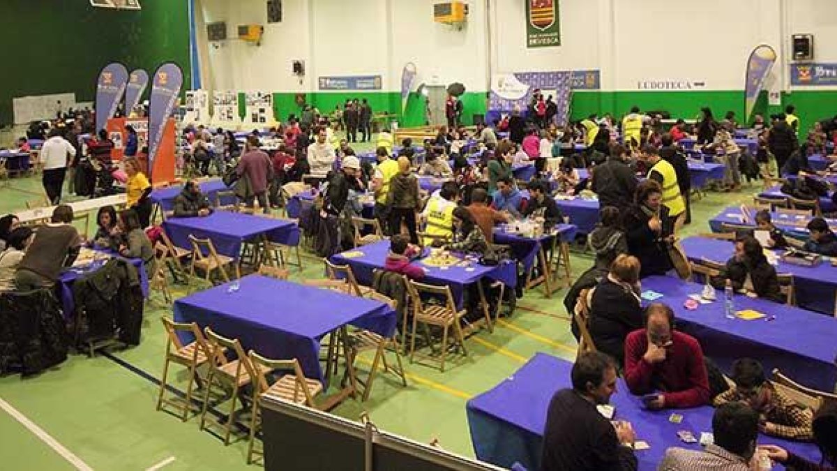 Asistentes de todas las edades juegan en las mesas habilitadas en el polideportivo para la celebración del evento.-G.G.