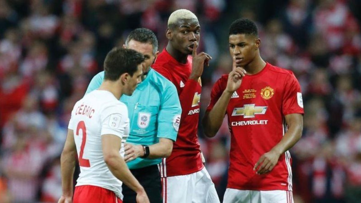 Paul Pogba (centro de la imágen) mandando callar a Cedric Soares.-AFP / IAN KINGTON