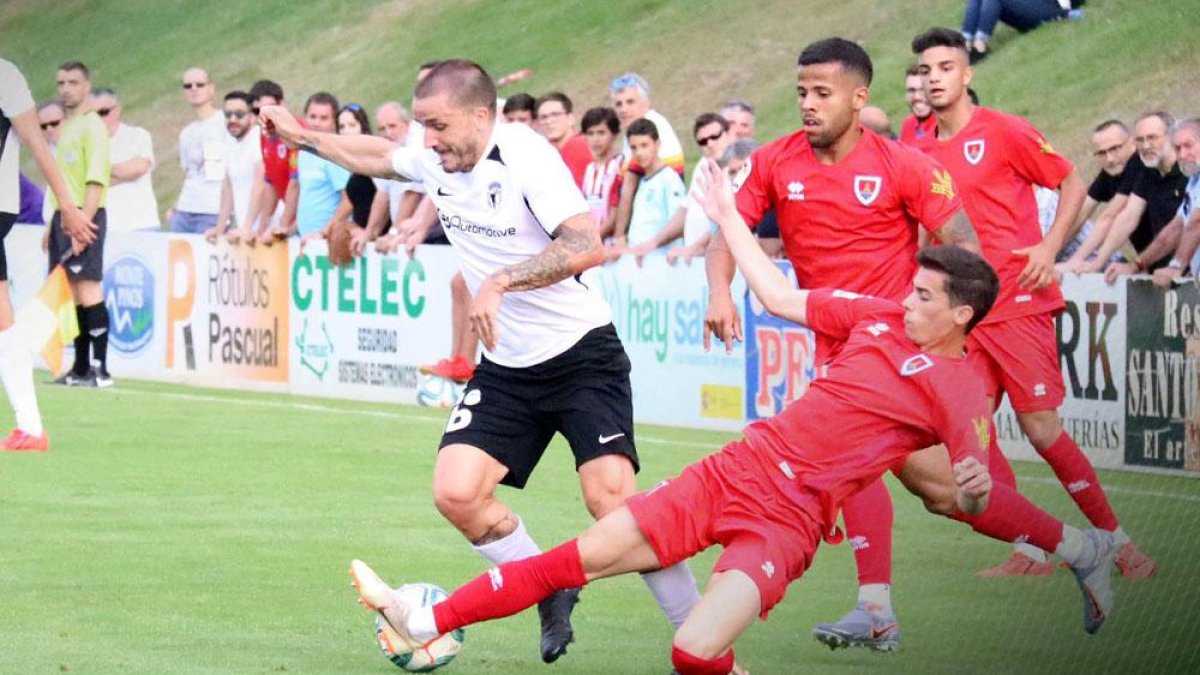 Borja Sánchez trata de zafarse del marcaje de un defensor del CD Numancia en el choque de ayer disputado en la Ciudad Deportiva Francisco Rubio de Soria-Burgos CF
