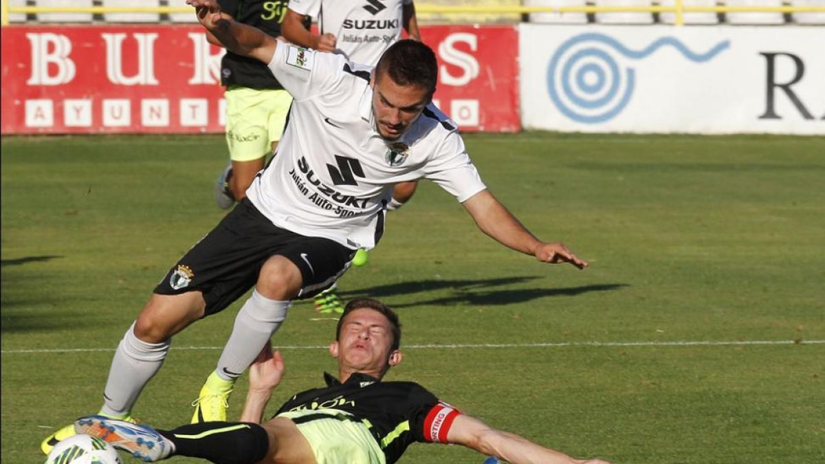 Óscar Ortega intenta avanzar ante la entrada de un rival, ayer, en El Plantío.-SANTI OTERO