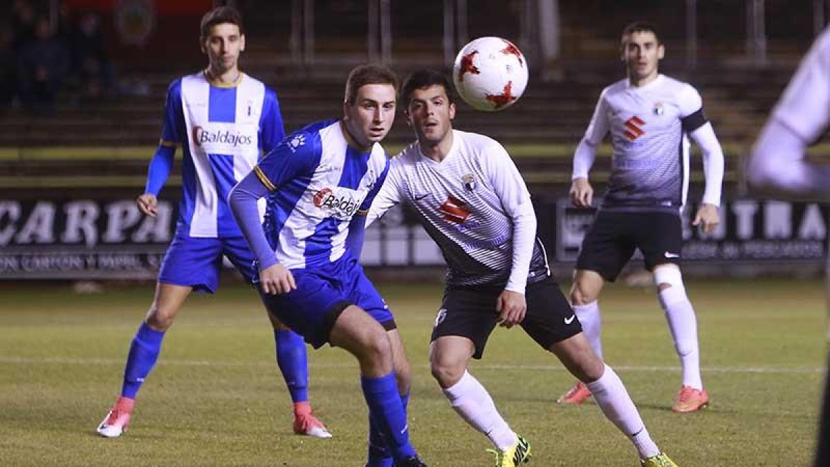 Manzano, muy participativo en el choque de ayer, cuerpea con un futbolista del Real Avilés-Raúl G. Ochoa