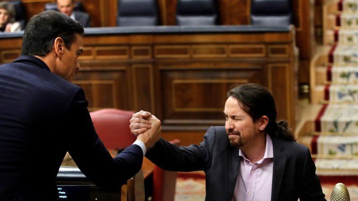 El líder de Unidas Podemos, Pablo Iglesias, saluda a Pedro Sánchez (i), tras su intervención ante el pleno del Congreso de los Diputados en la primera jornada de la sesión de investidura de Pedro Sánchez como presidente del Gobierno.-EFE