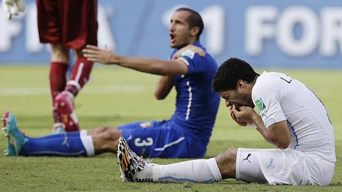 Momento en el que el delantero uruguayo agrede al defensa italiano, durante el partido correspondiente al Mundial de Brasil.-AP