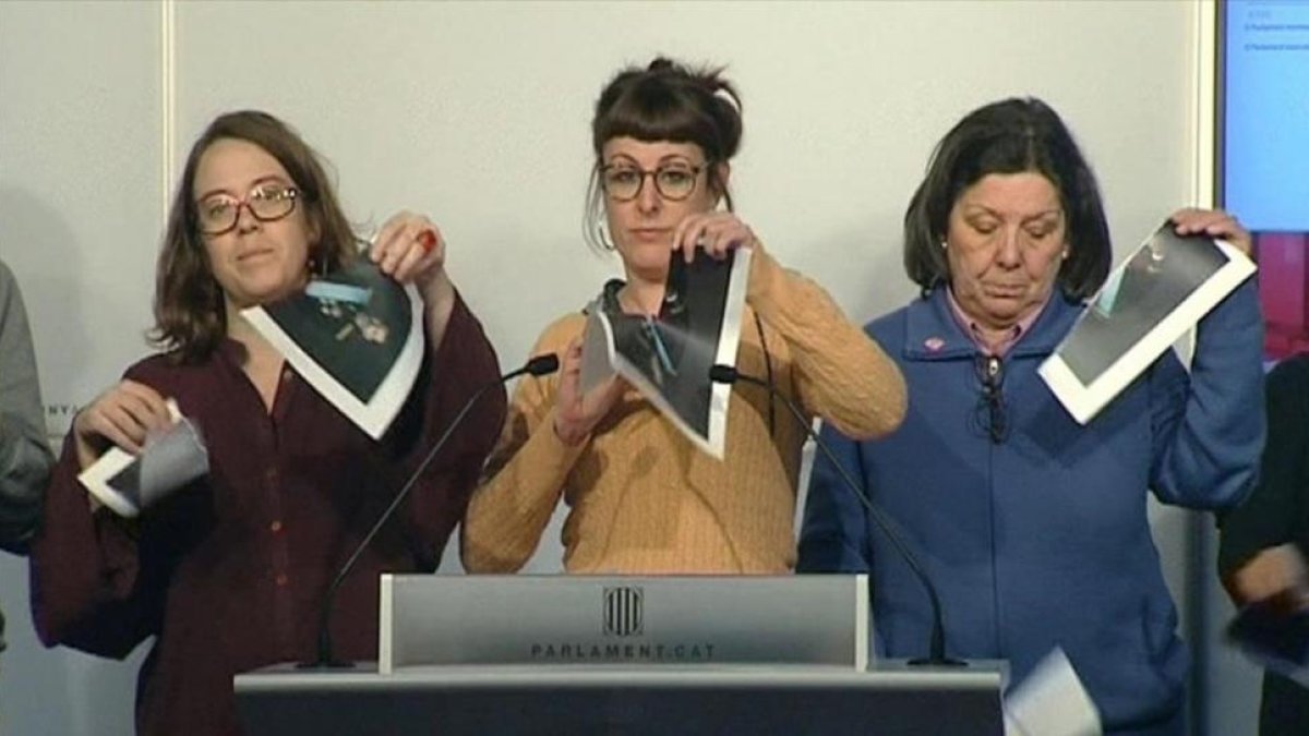 Las diputadas de la CUP Eulàlia Reguant, Mireia Vehí y Gabriela Serra rompen fotos del Rey en una rueda de prensa en el Parlament, el pasado día 12 de diciembre.-EFE